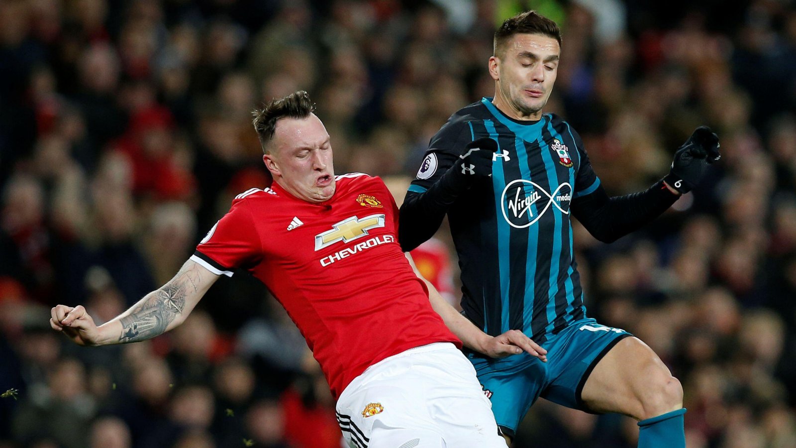Phil Jones tackles Dusan Tadic