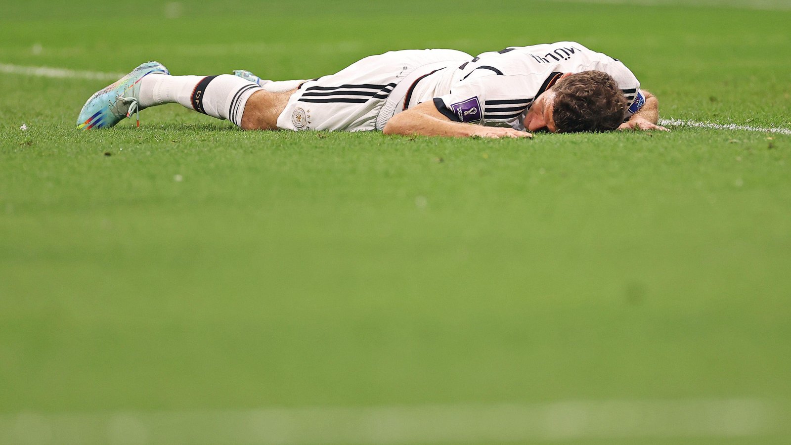 Germany forward Thomas Muller lies face down in the grass