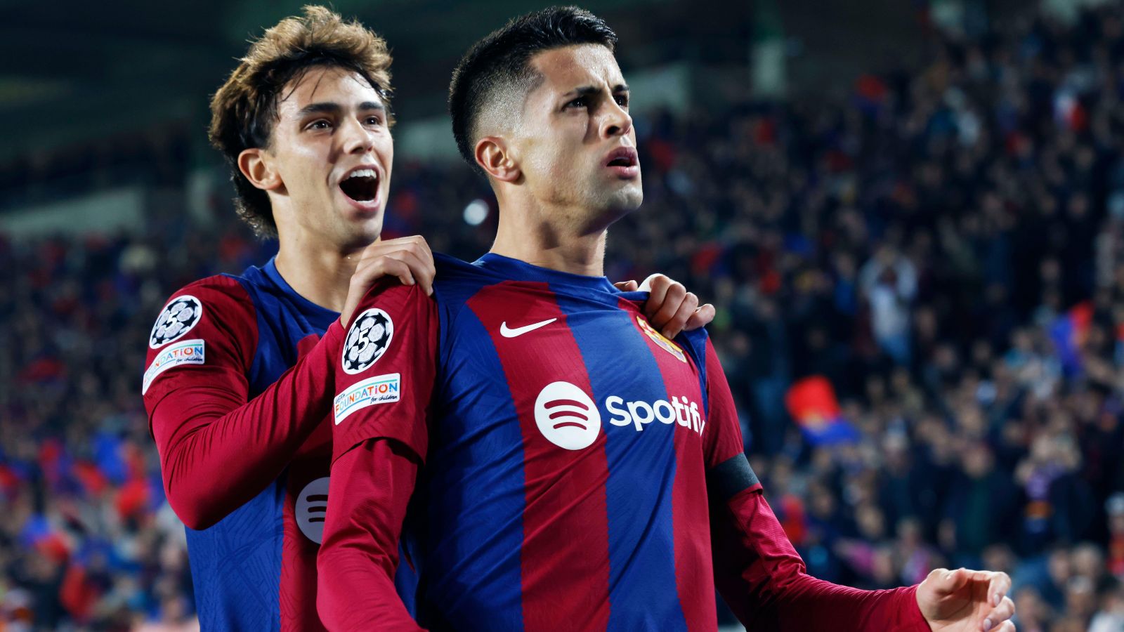 Barcelona players Joao Cancelo and Joao Felix celebrate a goal.