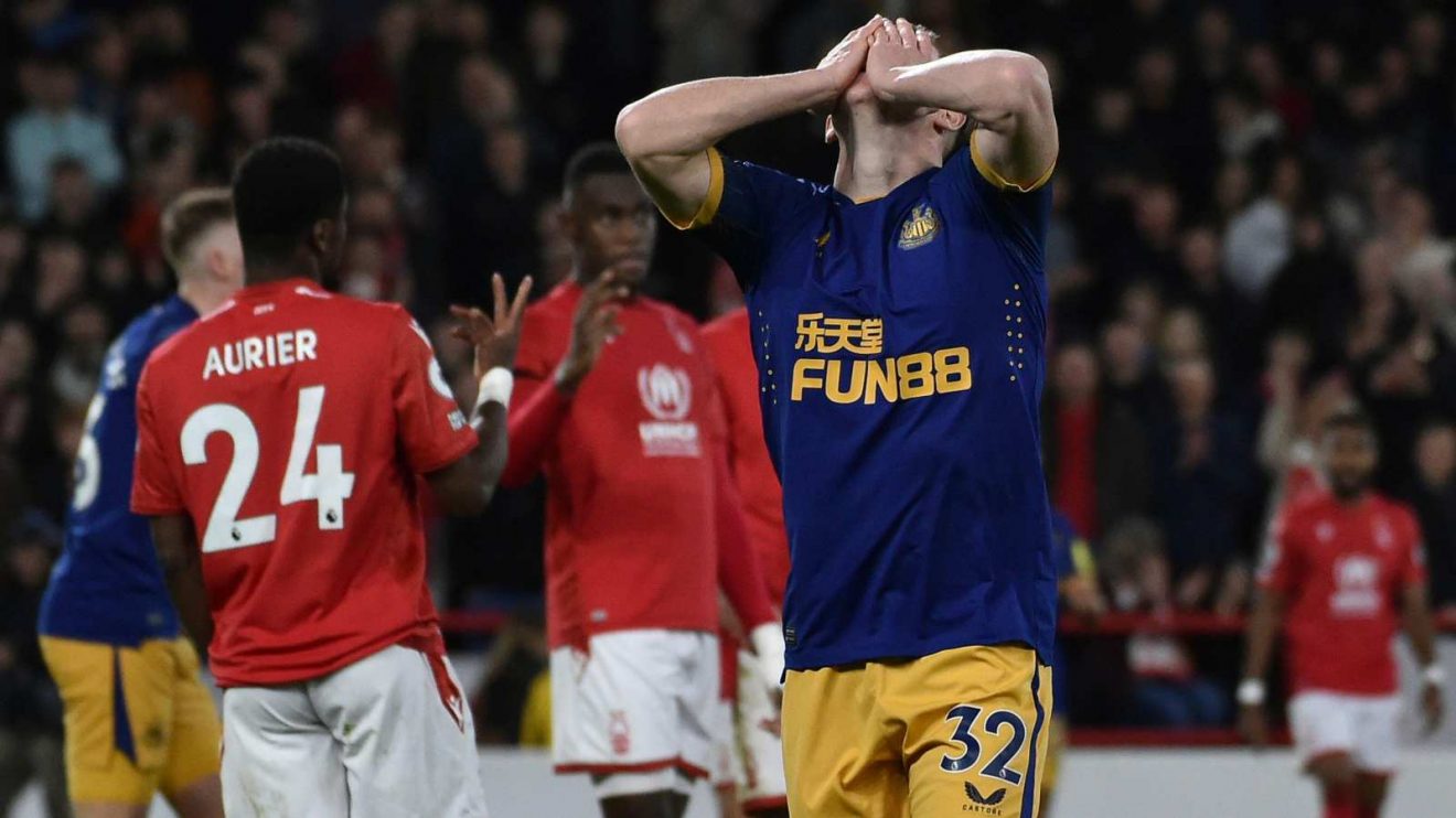 Newcastle midfielder Elliot Anderson holds his head in his hands during a match