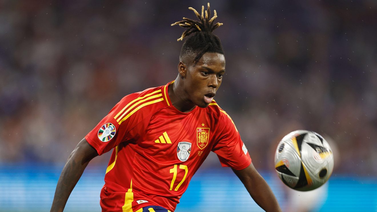 Nico Williams stares at a dropping ball while playing for Spain