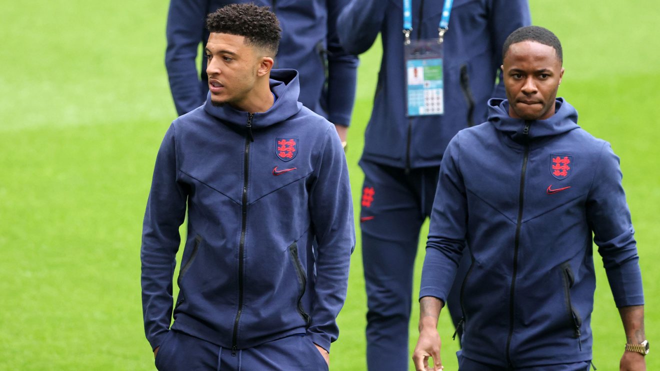 Jadon Sancho and Raheem Sterling walk around the pitch in tracksuits while on England duty