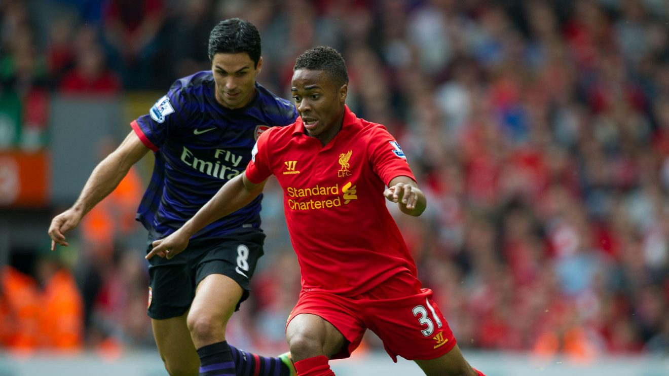 Mikel Arteta, playing for Arsenal, approaches then-Liverpool youngster Raheem Sterling from behind. They're playing football, to confirm.