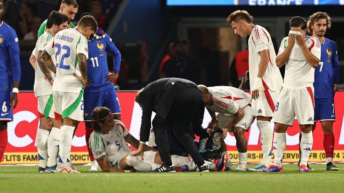 Arsenal defender Riccardo Calafiori receives treatment for an injured ankle during an Italy match