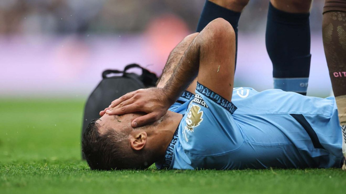 Man City midfielder Rodri holds his face in pain as he receives treatment for an injury