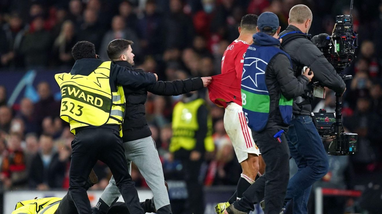 A pitch invader grabs Cristiano Ronaldo's Manchester United shirt