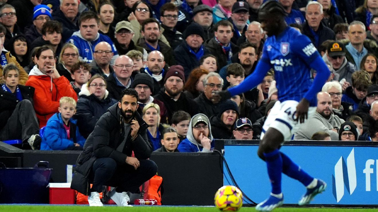 Ruben Amorim squats on the touchline at Portman Road as the match goes on before him