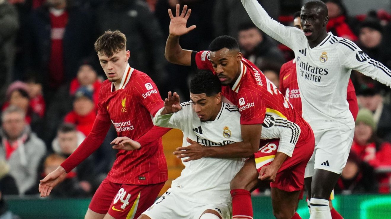 Real Madrid player Jude Bellingham shields the ball from Liverpool midfielder Ryan Gravenberch