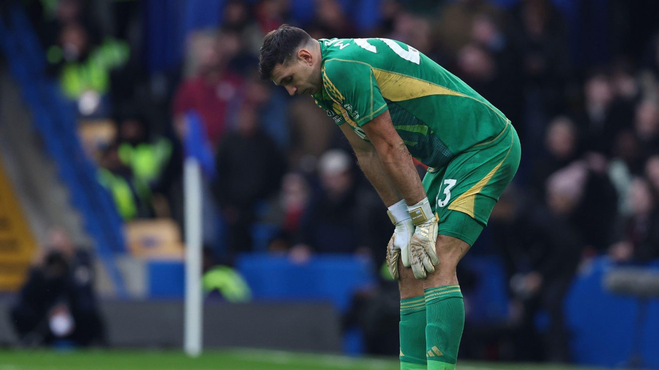 Emiliano Martinez stands hunched in a dejected pose with his hands on his thighs during Aston Villa's trip to Chelsea