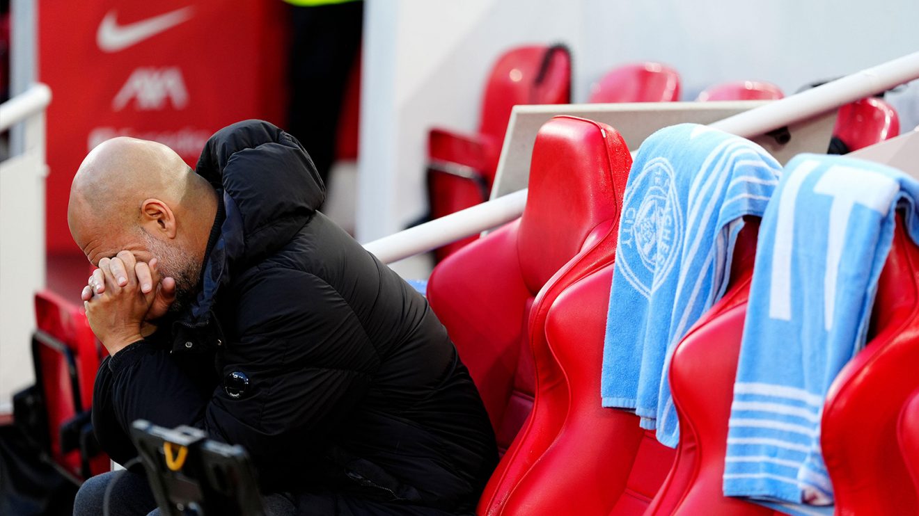 Pep Guardiola hunches over disconsolately in the Anfield dugout