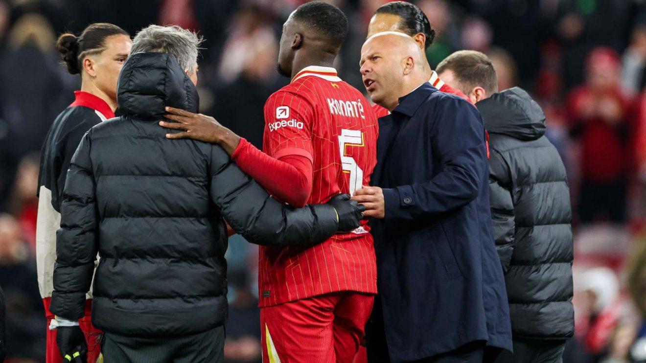 Liverpool head coach Arne Slot checks on the injured Ibrahima Konate