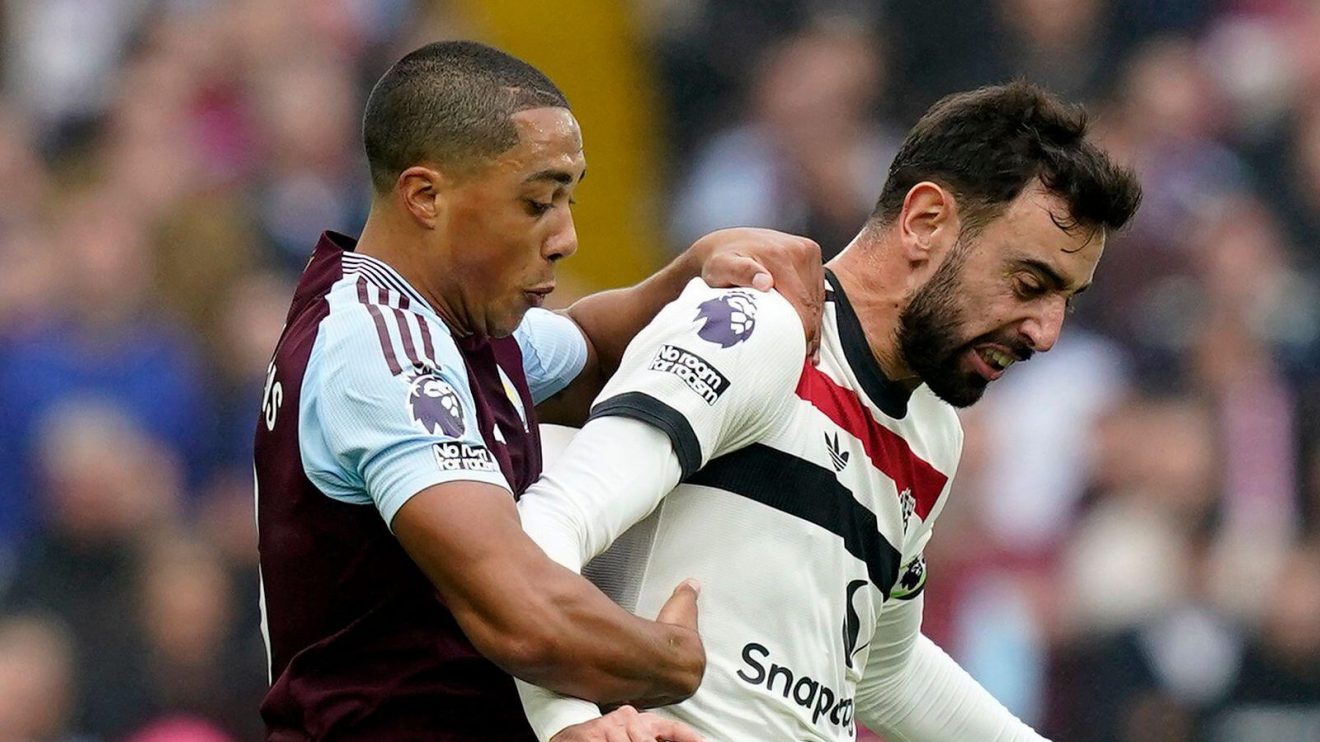 Aston Villa midfielder Youri Tielemans tackles Manchester United player Bruno Fernandes