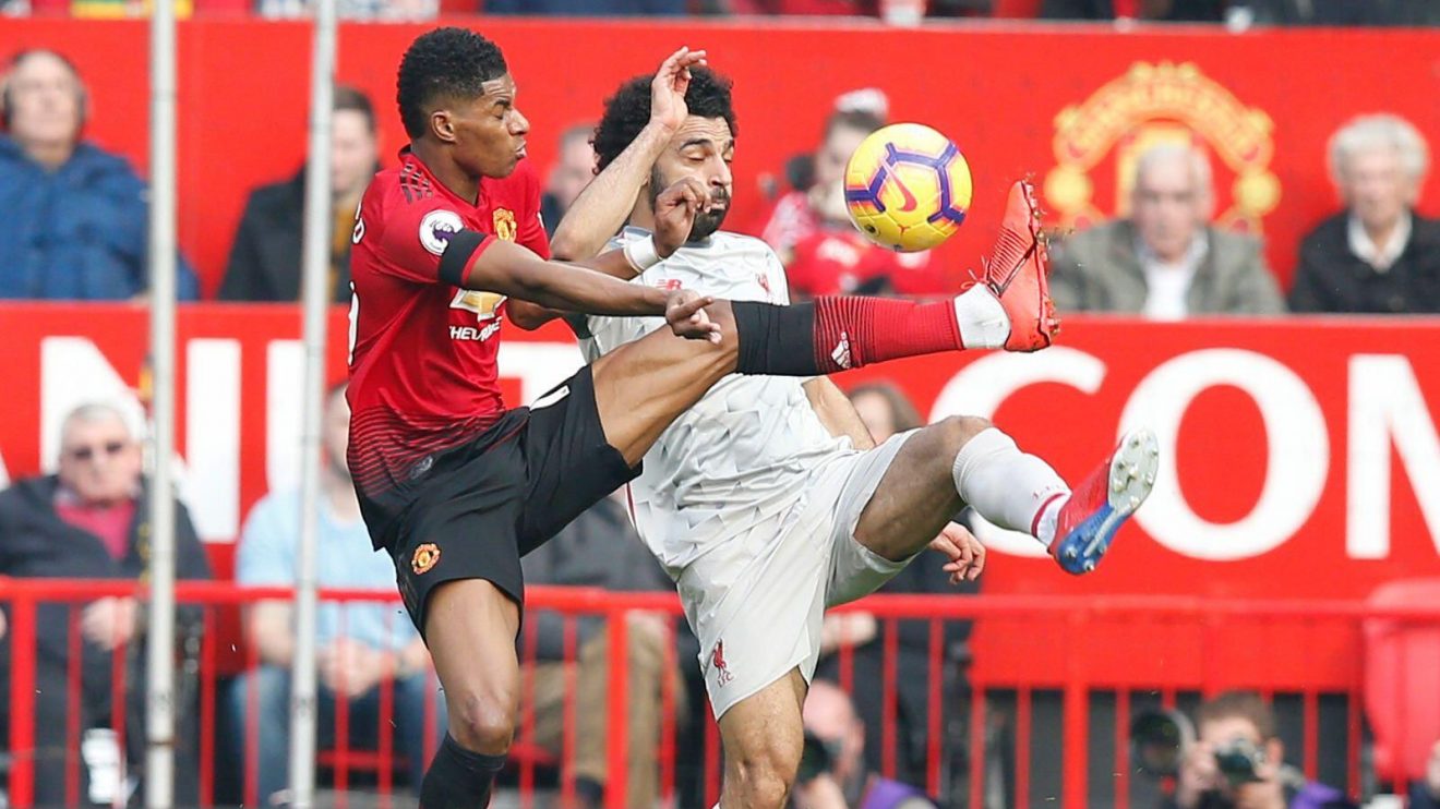 Manchester United forward Marcus Rashford competes for the ball with Liverpool striker Mo Salah