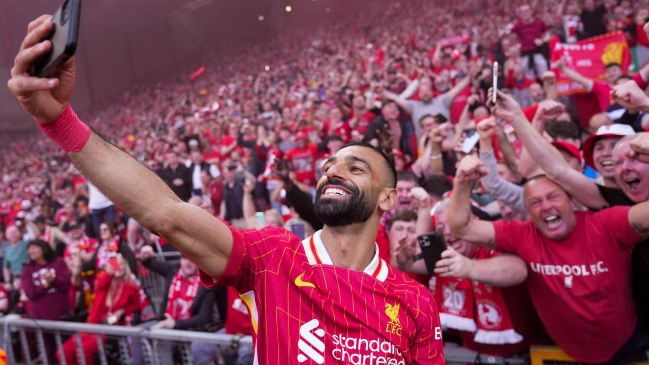 Liverpool forward Mohamed Salah takes a selfie in front of the Kop