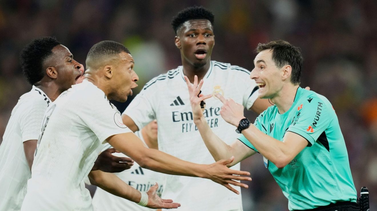Real Madrid players surround the referee