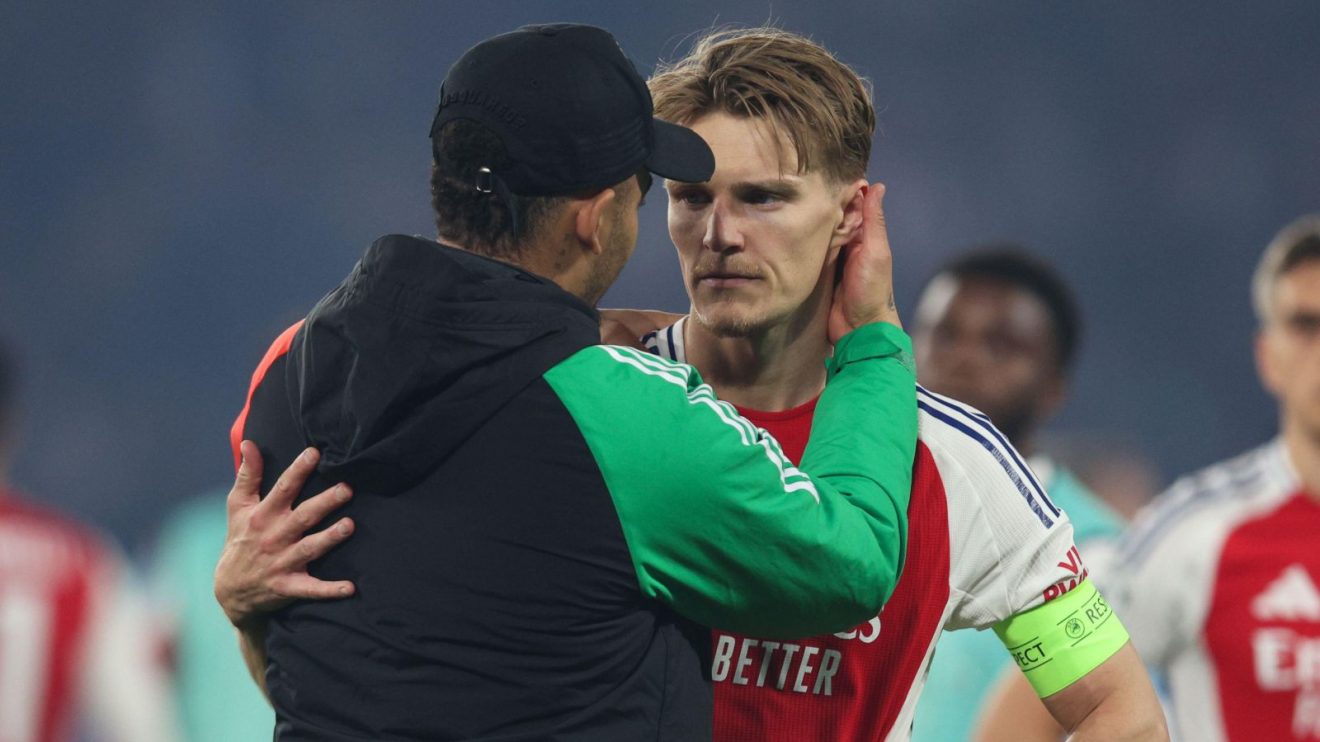 An Arsenal coach talks to a dejected Martin Odegaard