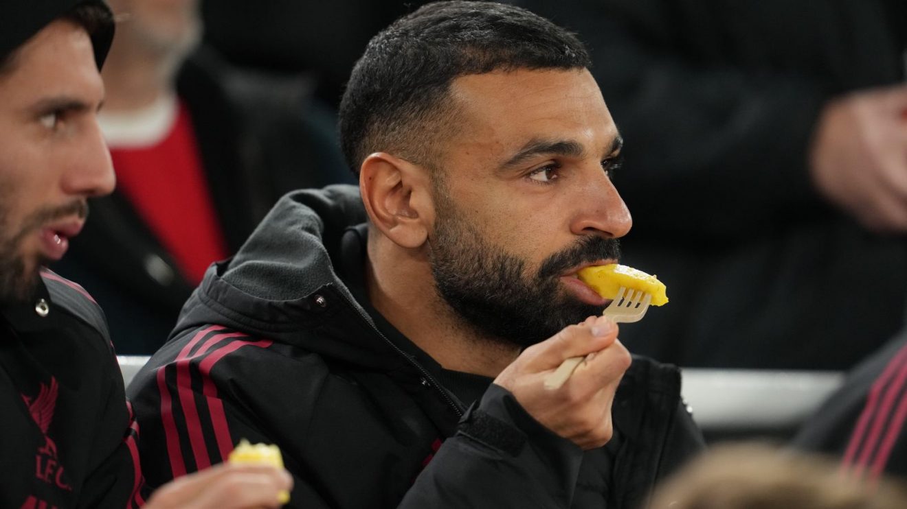 Liverpool forward Mohamed Salah eating fruit while sat on the bench