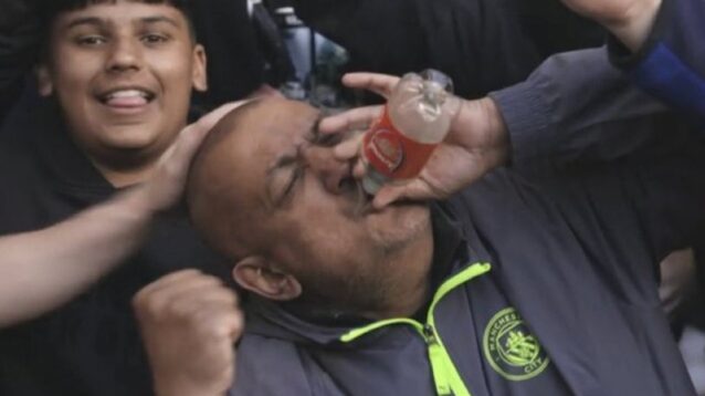 Man City fan drinking from Arsenal bottle