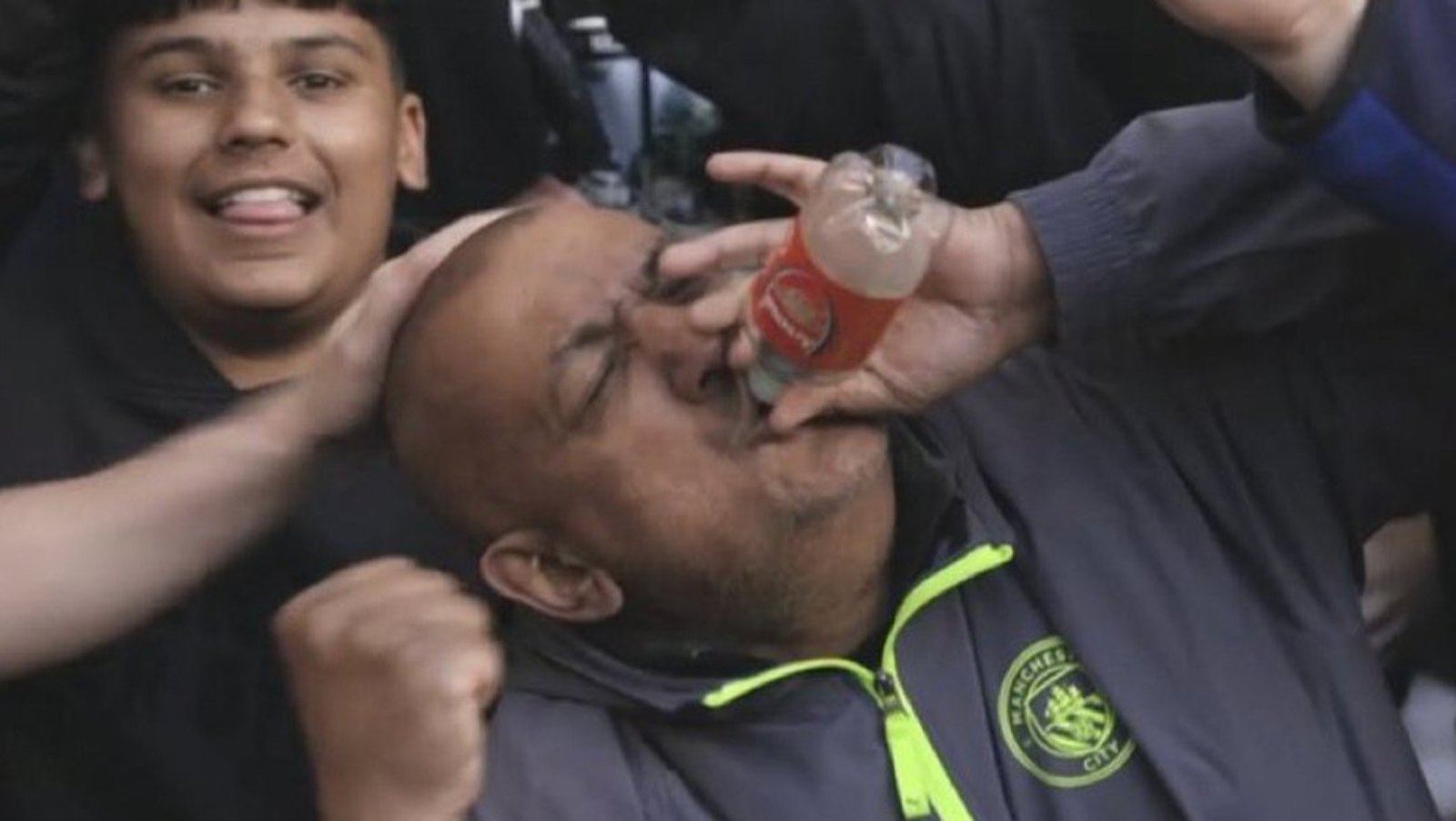 Man City fan drinking from Arsenal bottle