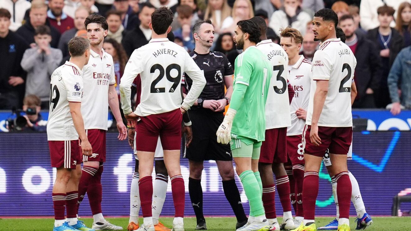 Arsenal players surround referee