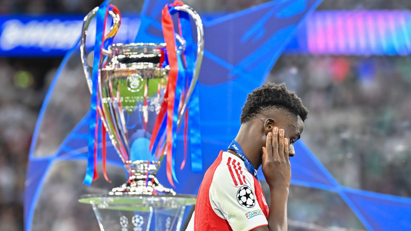 Bukayo Saka with Champions League trophy