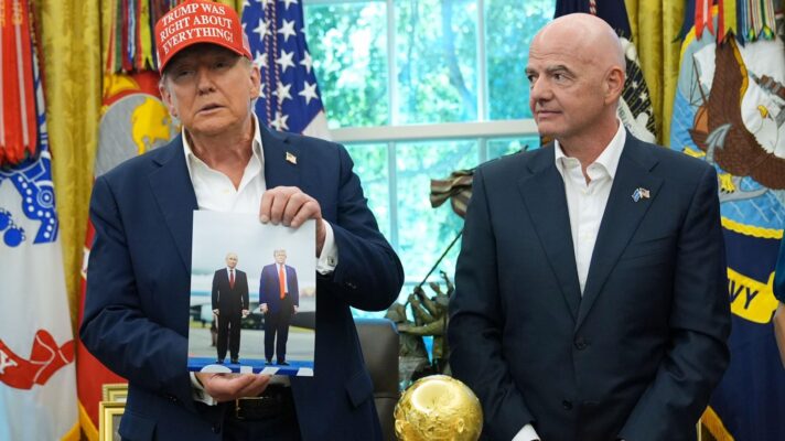 Donald Trump holds a photo with Vladimir Putin with Gianni Infantino.