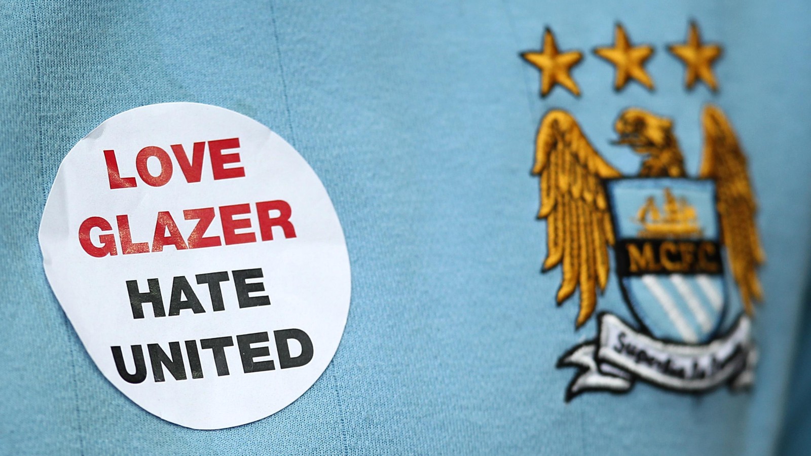 A Manchester City shirt featuring the badge and support for the Glazers